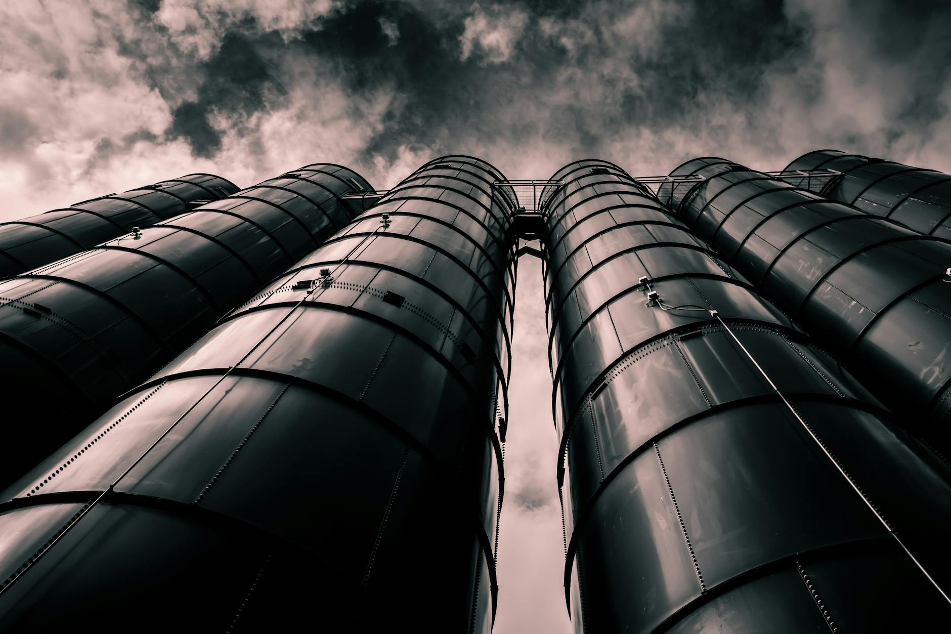 Crude Oil to Toluene: 8 Powerful Production Steps 1 Low angle view of industrial silos with a dramatic cloudy sky in the background, emphasizing modern industry.